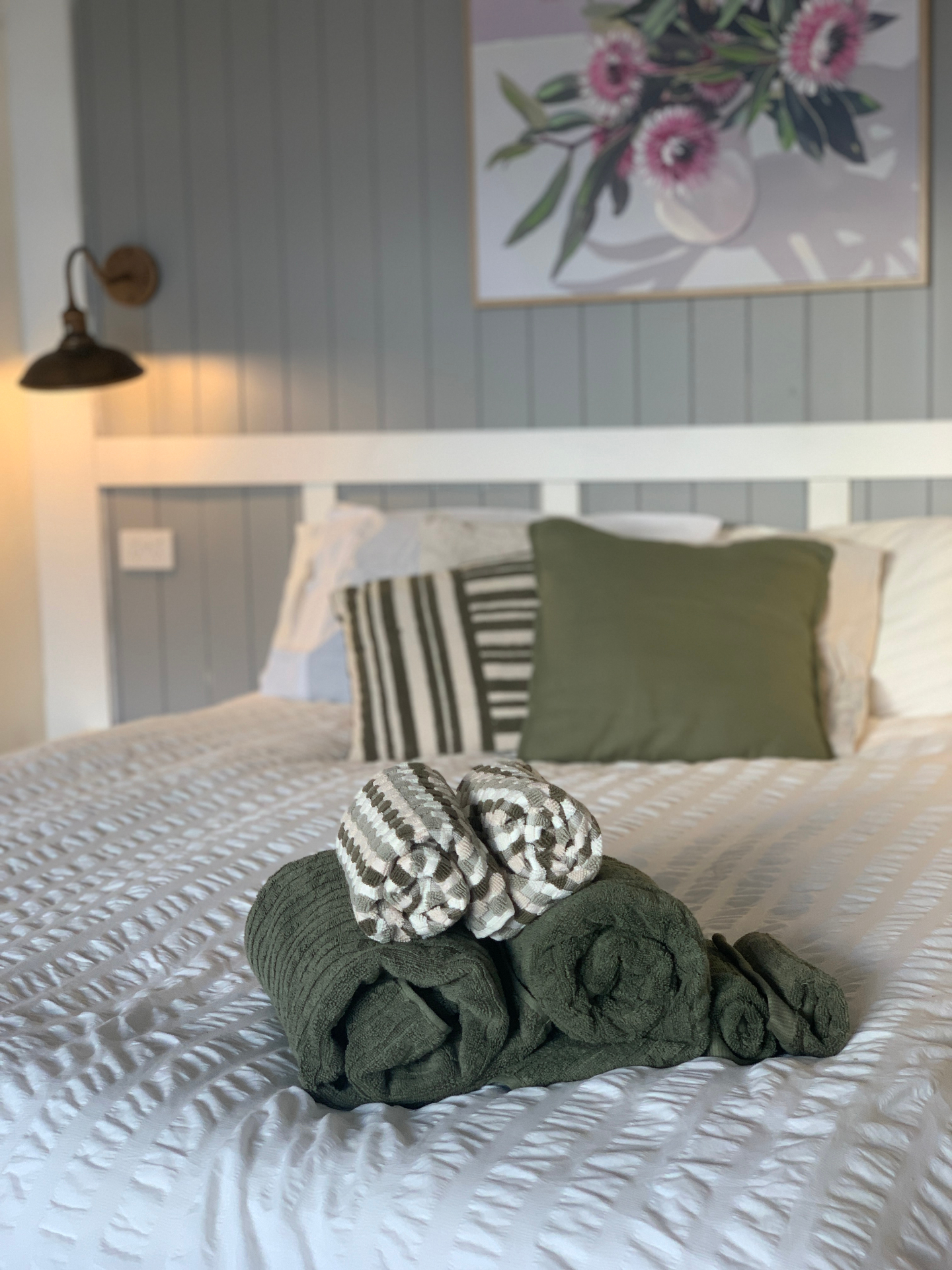 King bed dressed with linen, fresh towels rolled and waiting
