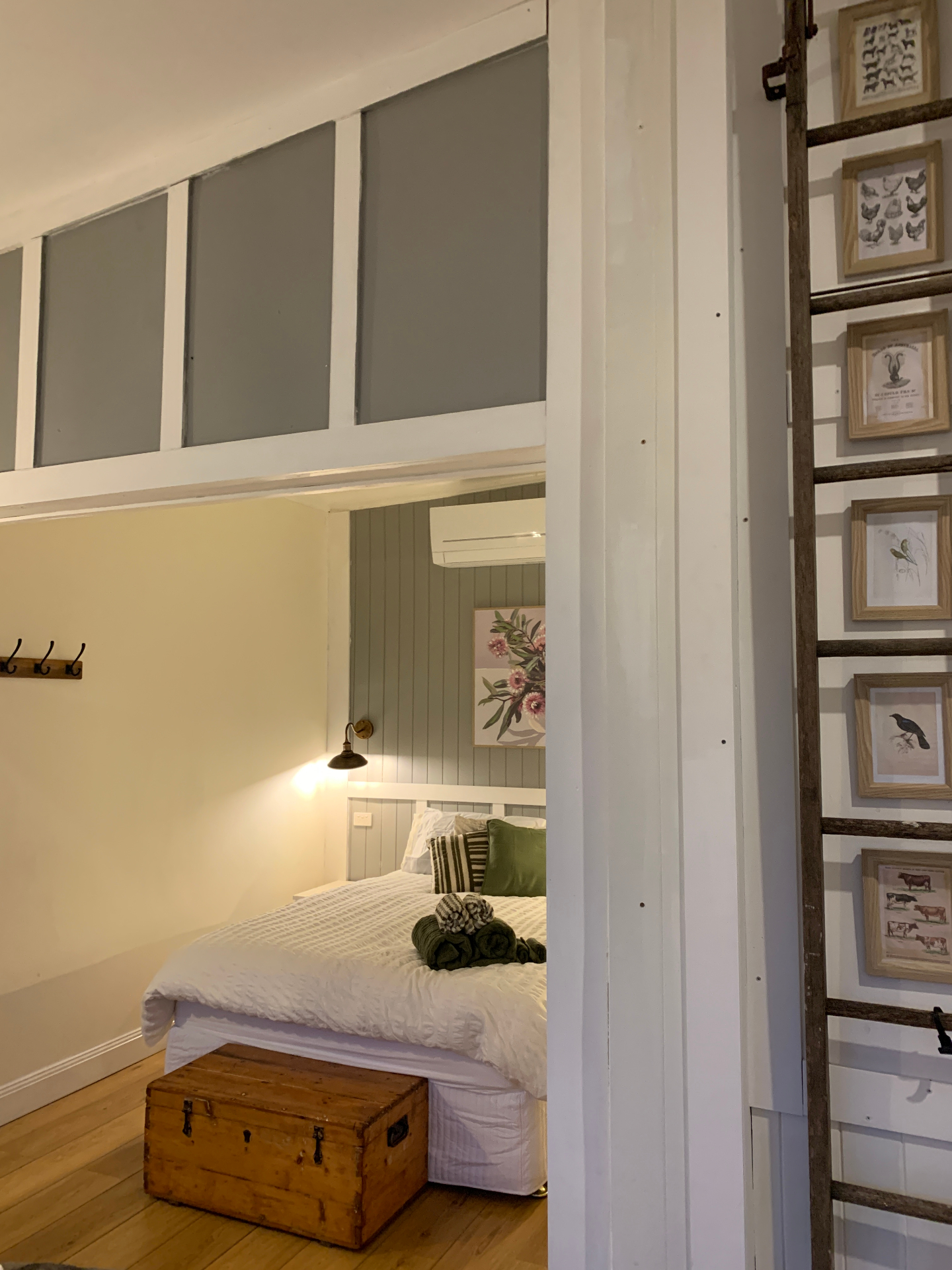 Loft bedroom nook with ladder and gallery wall of botanical prints
